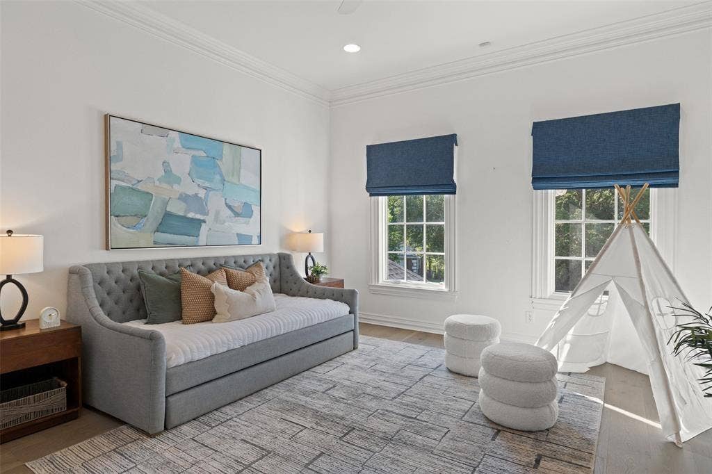 4201 Green Cliffs Road, Austin, TX 78746 Bright room featuring two large windows with blue Roman shades, crown molding, and wood-finish flooring