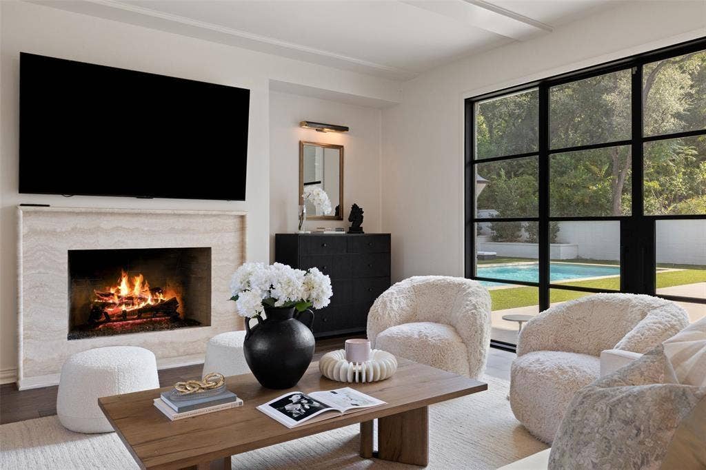 4201 Green Cliffs Road, Austin, TX 78746 Travertine surround fireplace, dark wood-finish flooring, metal-framed window, built-in cabinetry, and integrated ceiling lighting