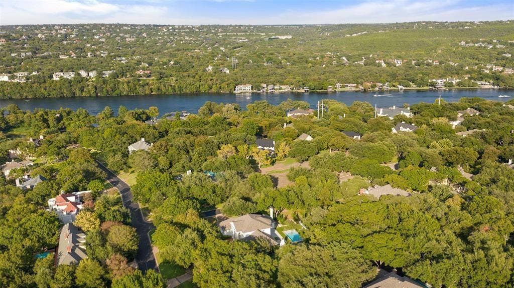4201 Green Cliffs Road, Austin, TX 78746 Residential area surrounded by mature trees, featuring a river and hills in the background