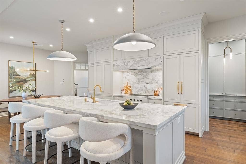 4201 Green Cliffs Road, Austin, TX 78746 Expansive kitchen island with a stone countertop, built-in cabinetry, and a gold-finish faucet