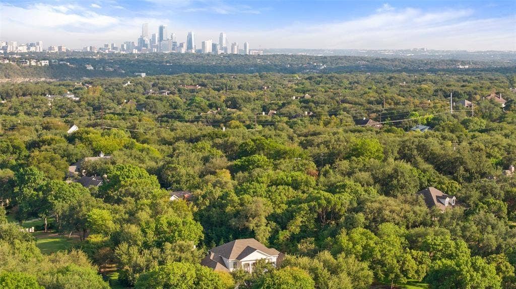 4201 Green Cliffs Road, Austin, TX 78746 Expansive treed landscape with a visible cityscape in the distance