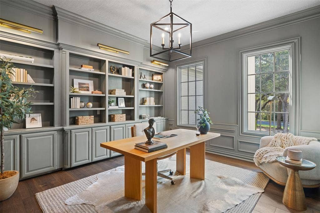 4201 Green Cliffs Road, Austin, TX 78746 Built-in gray cabinetry with open shelving, wood-finish flooring, full-height windows, wall sconces, and a geometric chandelier