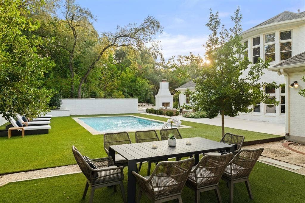 4201 Green Cliffs Road, Austin, TX 78746 Expansive backyard with a swimming pool, artificial turf, and a built-in outdoor fireplace