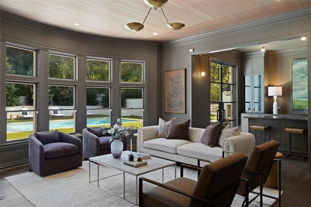 4201 Green Cliffs Road, Austin, TX 78746 Curved wall of windows, hardwood flooring, built-in wet bar with cabinetry, recessed lighting, and a modern chandelier