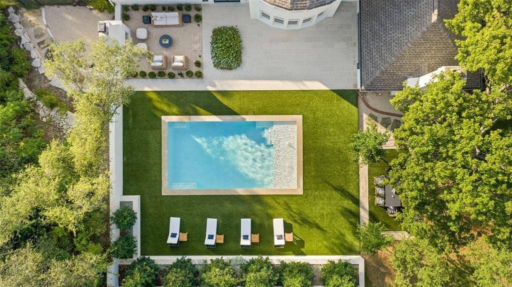4201 Green Cliffs Road, Austin, TX 78746 Expansive backyard featuring a rectangular swimming pool, surrounding green lawn, and multiple paved patio areas