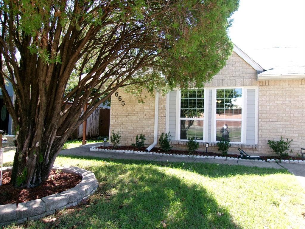 665 Stonewall Drive, Grand Prairie, TX 75052 Light-colored brick exterior with decorative shutters