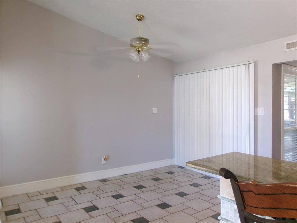 665 Stonewall Drive, Grand Prairie, TX 75052 Ceramic tile flooring with a geometric pattern, ceiling fan with integrated lighting, vertical blinds, and a built-in countertop with a polished surface
