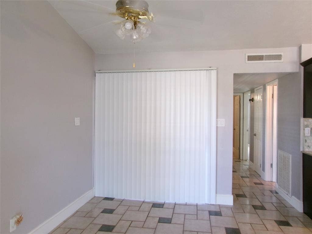 665 Stonewall Drive, Grand Prairie, TX 75052 Ceiling fan with integrated lighting, vertical blinds, light-toned wall paint, patterned tile flooring, and white trim