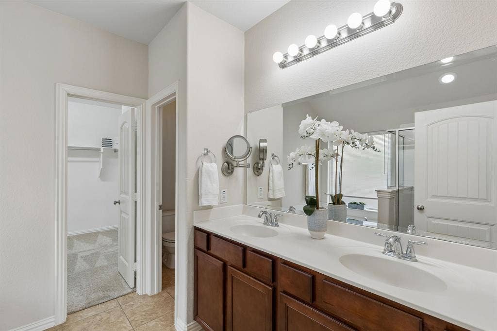 1906 Faircrest Lane, Wylie, TX 75098 The primary bathroom offers dual sinks, chrome fixtures and nice under vanity storage. The separate WC is private.