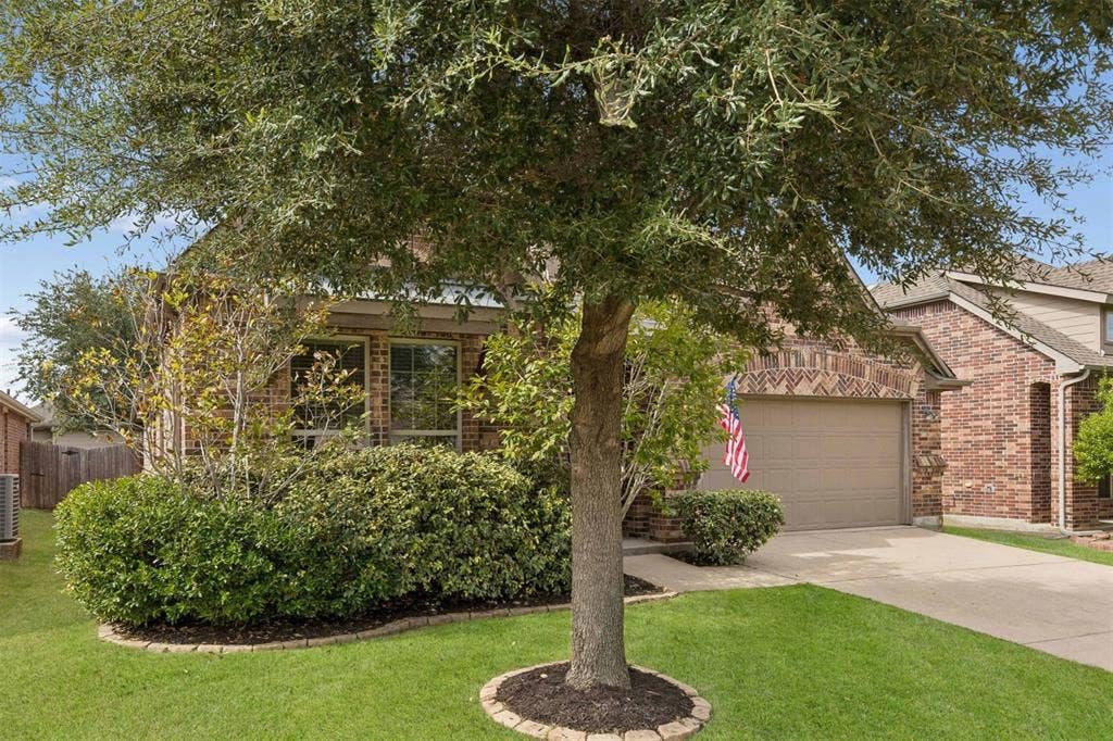 1906 Faircrest Lane, Wylie, TX 75098 The home has inviting curb appeal with lush mature foliage and striking brick exterior.