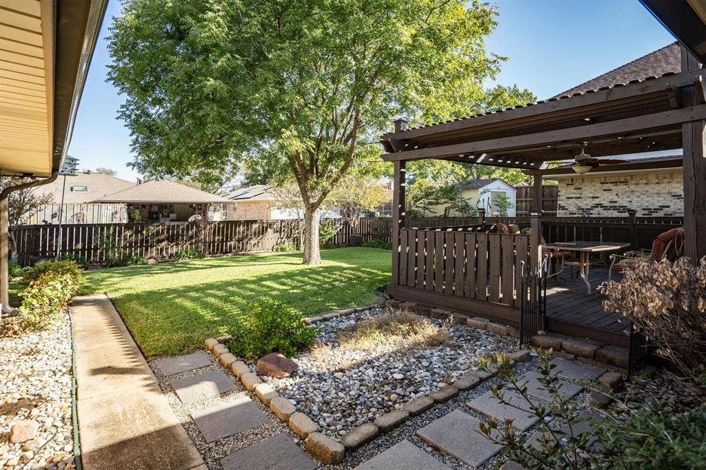 1305 Stonewood Drive, Carrollton, TX 75006 Spacious backyard with deck, shade pergola, and low-maintenance landscaping