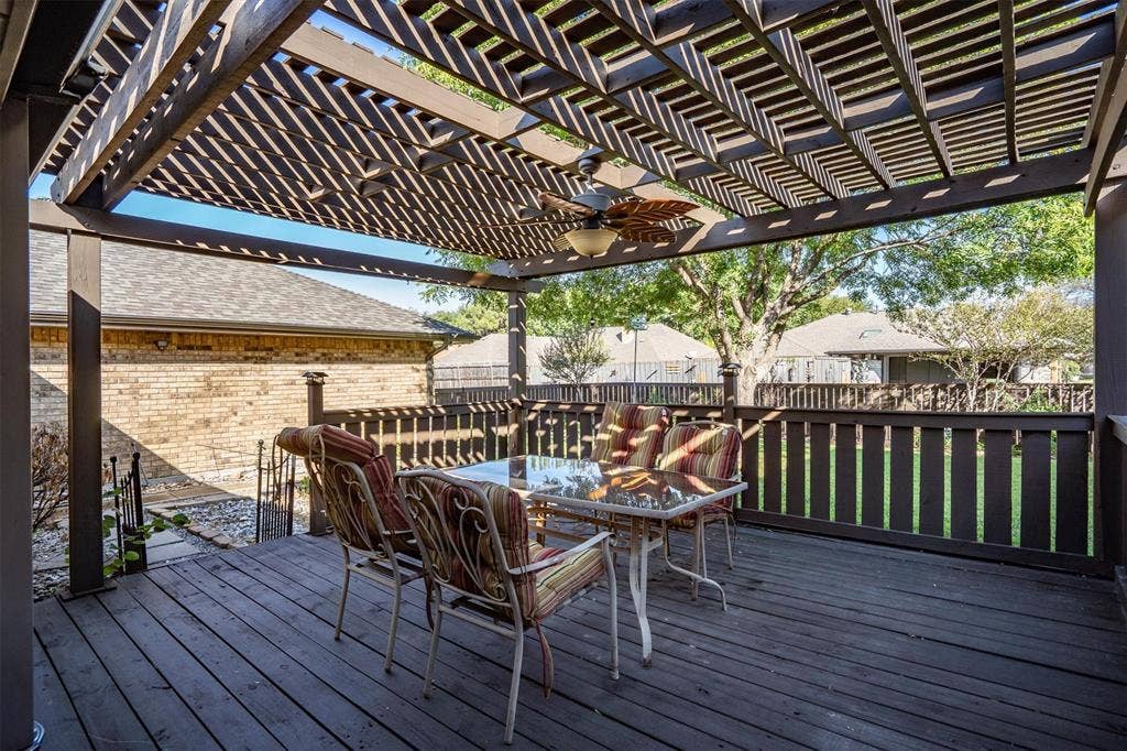 1305 Stonewood Drive, Carrollton, TX 75006 Expansive wooden deck with a shade pergola, perfect for outdoor dining and relaxation