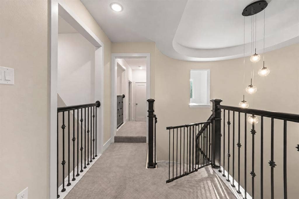 2628 Camden Court, Celina, TX 75009 Neutral carpeting, wrought iron stair railing with ornate finials, tiered multi-globe pendant lighting, and recessed ceiling architecture