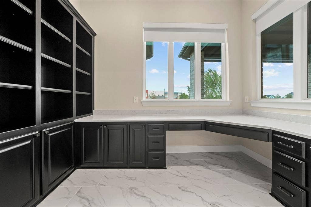 2628 Camden Court, Celina, TX 75009 Built-in floor-to-ceiling cabinetry, L-shaped desk with stone countertop, large windows, and tile flooring