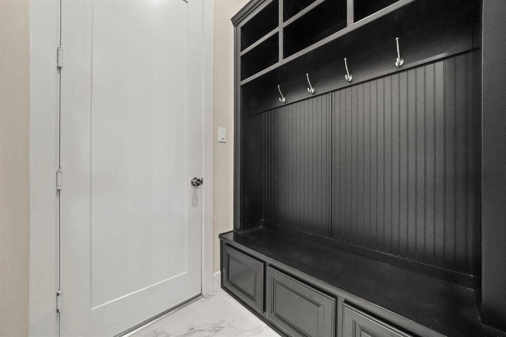 2628 Camden Court, Celina, TX 75009 Built-in mudroom cabinetry featuring dark finish shaker-style lower drawers, beadboard paneling, integrated upper shelving, and metallic hooks, set against light-toned flooring