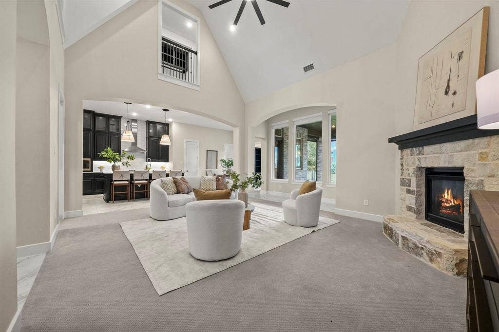 2628 Camden Court, Celina, TX 75009 Vaulted ceilings, floor-to-ceiling stone fireplace, interior balcony, and arched window detailing