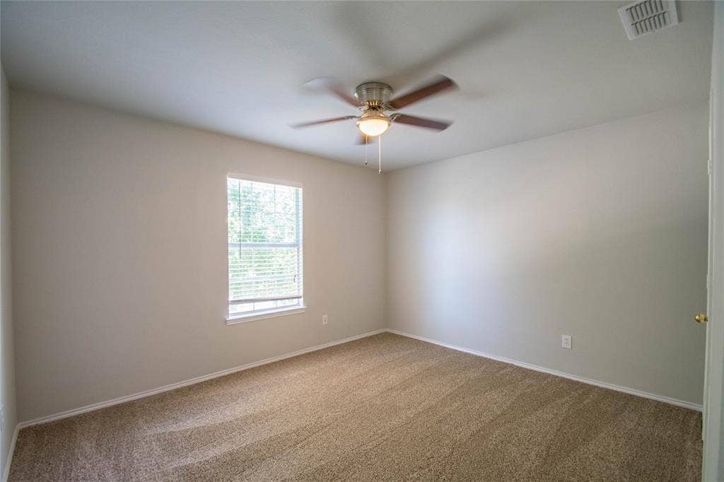 Carpeted room featuring light-colored walls, a single window with blinds, and a ceiling fan with integrated lighting