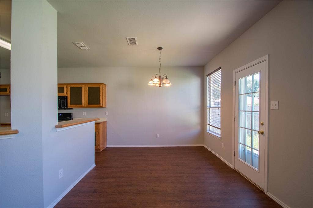 Wood-finish flooring with a chandelier lighting fixture