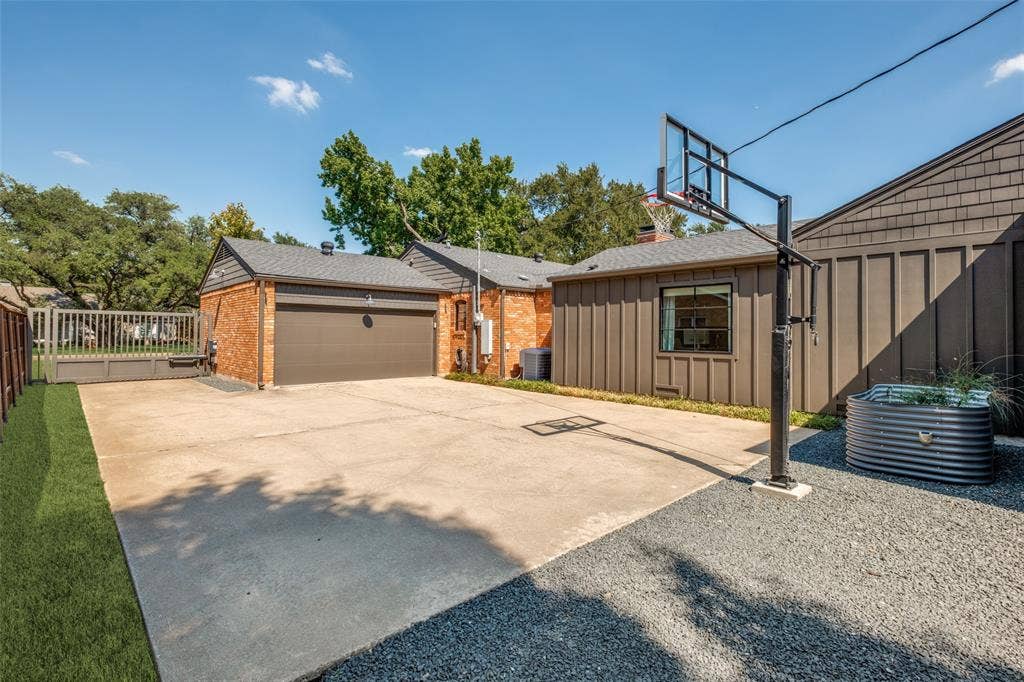 5222 Meadow Crest Drive, Dallas, TX 75229 Side yard with electric gated driveway, in ground basketball goal, additional off street parking and raised vegetable bedSide yard with electric gated driveway, in ground basketball goal, add'l off street parking & raised vegetable bed