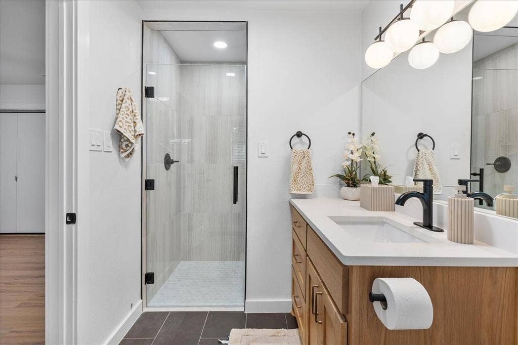 Wood-finish vanity with an integrated sink and matte black faucet