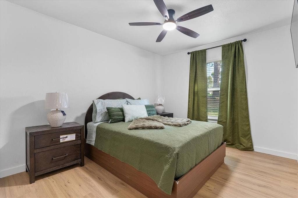 Light-toned wood-finish flooring, white walls, and a window with blinds