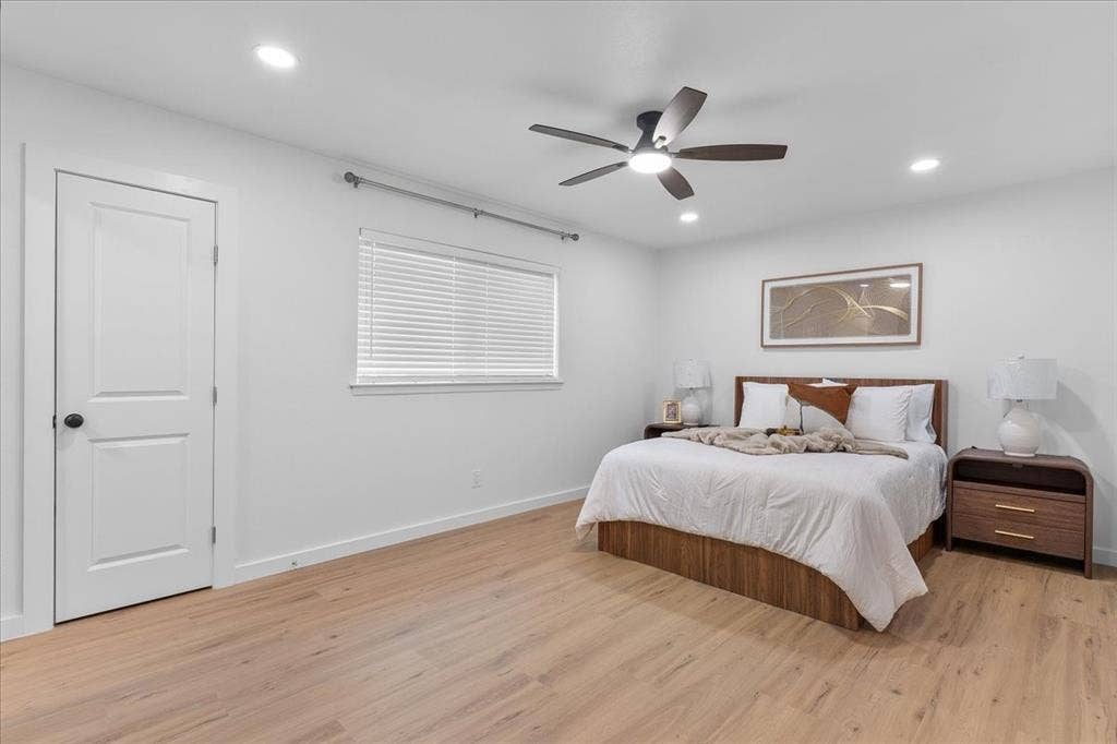 Recessed lighting, wood-finish flooring, white walls, ceiling fan, and a window with horizontal blinds