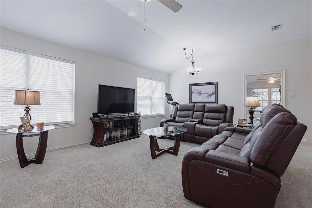 2918 Periwinkle Court, Garland, TX 75040 Vaulted ceiling with a ceiling fan, neutral carpet flooring, and multiple windows