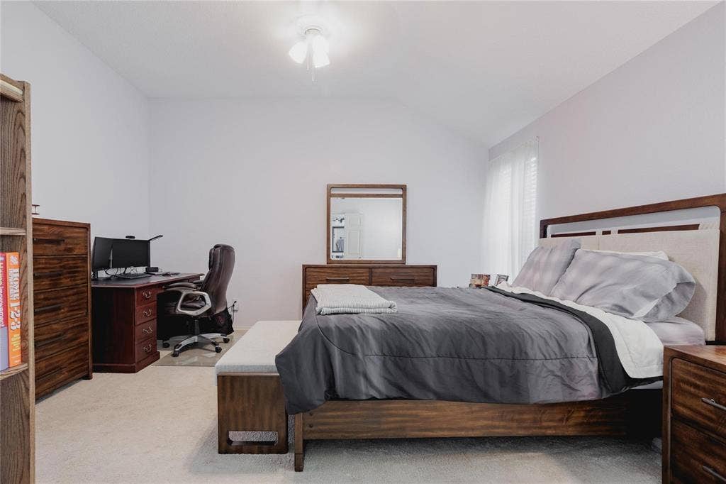 2918 Periwinkle Court, Garland, TX 75040 Vaulted ceiling with a flush-mount ceiling light fixture, wall-to-wall carpeting, and a window with blinds and sheer curtains