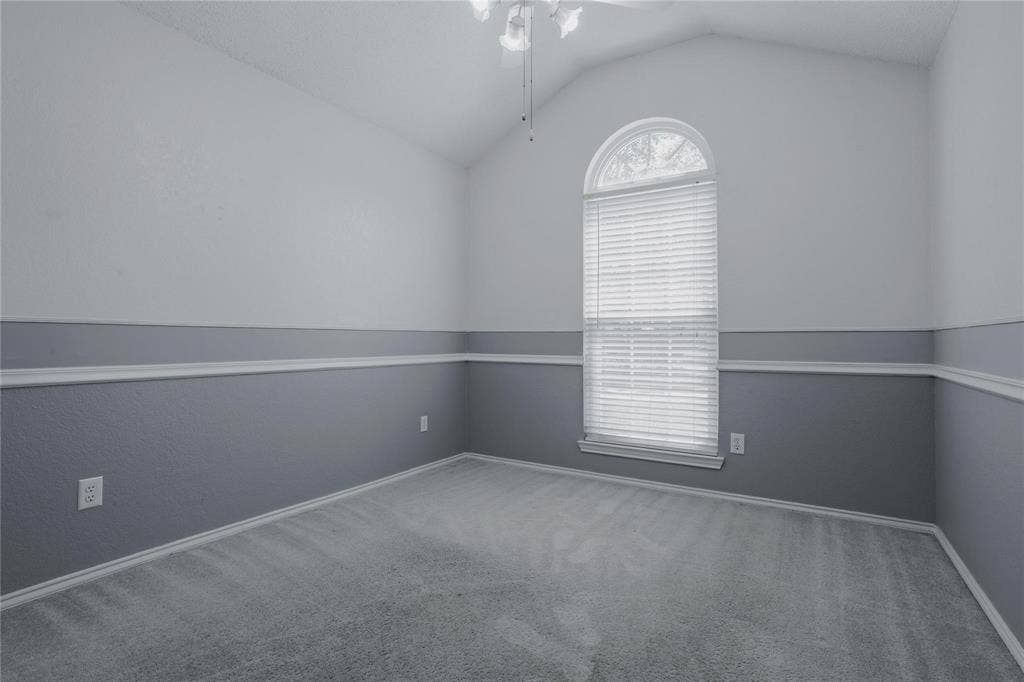 2918 Periwinkle Court, Garland, TX 75040 Vaulted ceiling with a ceiling fan, arched window with blinds, two-tone wall treatment, decorative chair rail molding, and soft carpeting