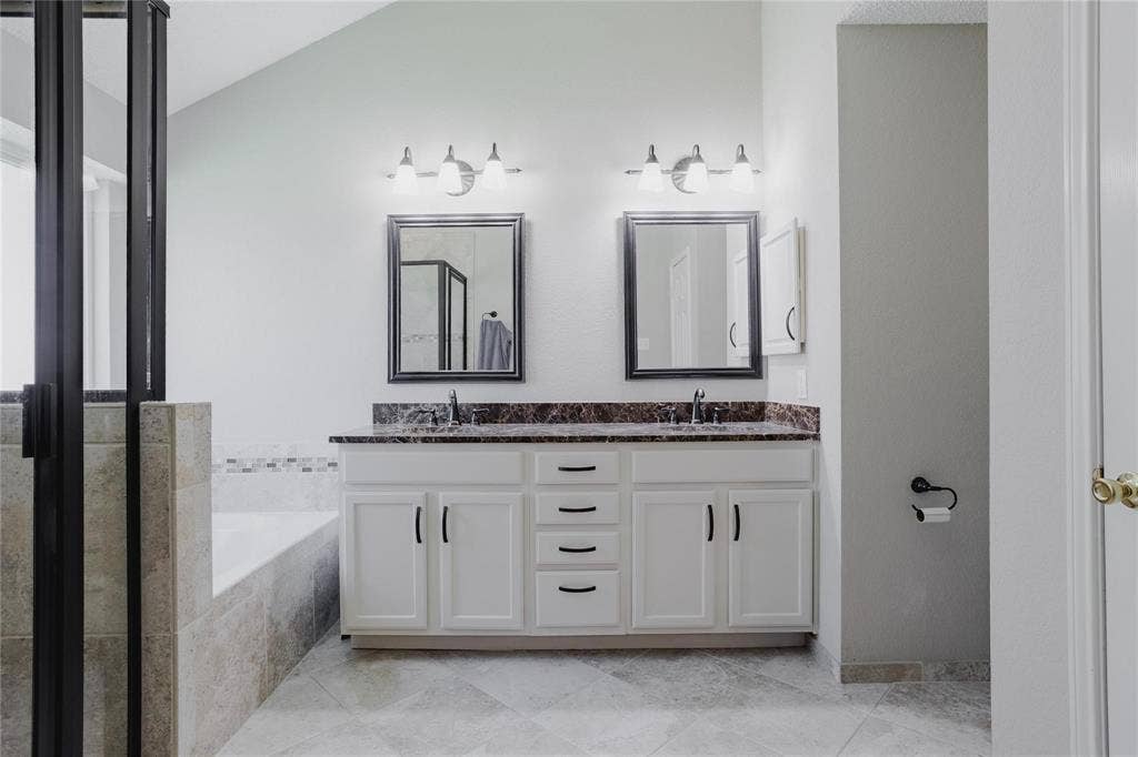 2918 Periwinkle Court, Garland, TX 75040 Dual vanity with white cabinetry and dark countertops