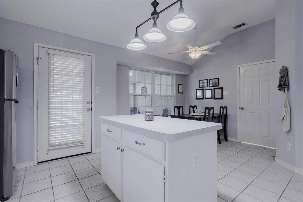 2918 Periwinkle Court, Garland, TX 75040 Central kitchen island with white cabinetry and a white countertop