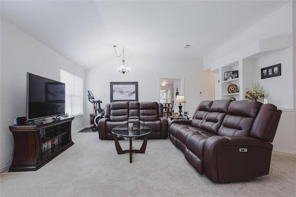2918 Periwinkle Court, Garland, TX 75040 Vaulted ceiling, recessed lighting, built-in shelving, chandelier, and a window with blinds