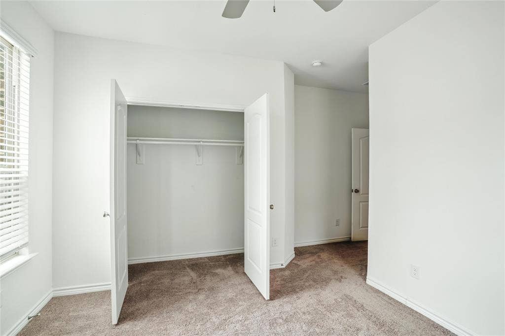 Unfurnished bedroom with carpet floors, a closet, and a ceiling fan