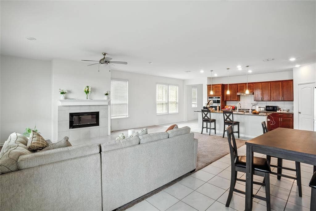 Living area featuring recessed lighting, light tile patterned flooring, a fireplace, and ceiling fan