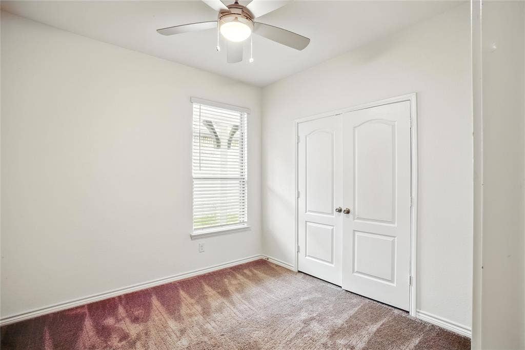 Unfurnished bedroom featuring carpet, a closet, and a ceiling fan