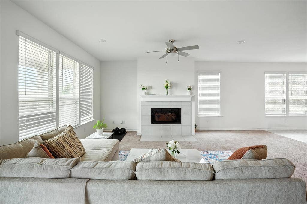 Living room featuring healthy amount of natural light, a tile fireplace, and light carpet