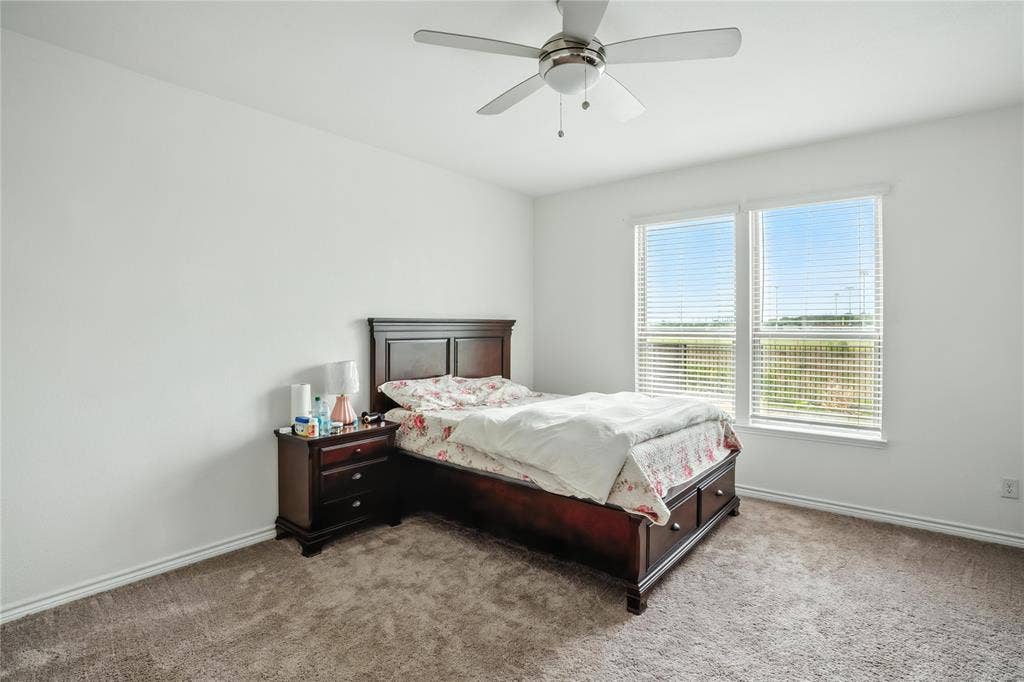 Bedroom featuring light colored carpet and ceiling fan