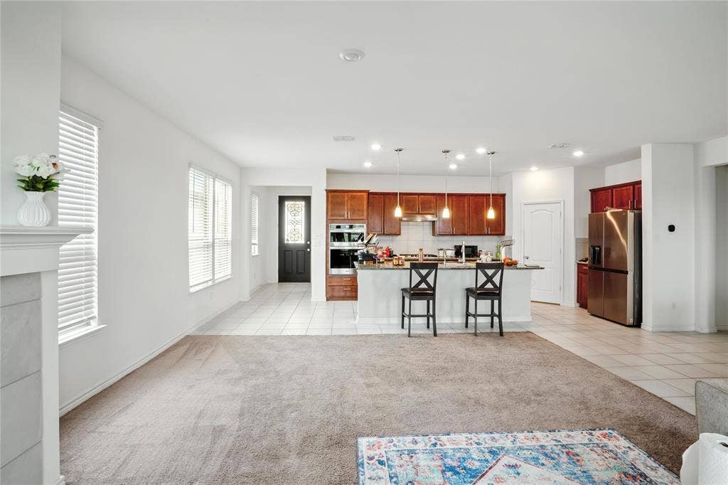 Kitchen with light tile patterned floors, appliances with stainless steel finishes, light carpet, tasteful backsplash, and recessed lighting