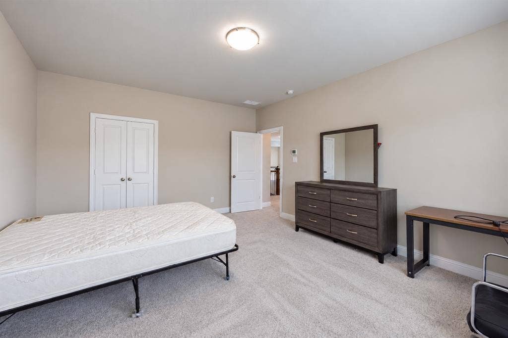 1603 Coventry Court, Farmers Branch, TX 75234 Neutral tone wall paint, light-colored carpeting, white trim, and a flush mount ceiling light fixture