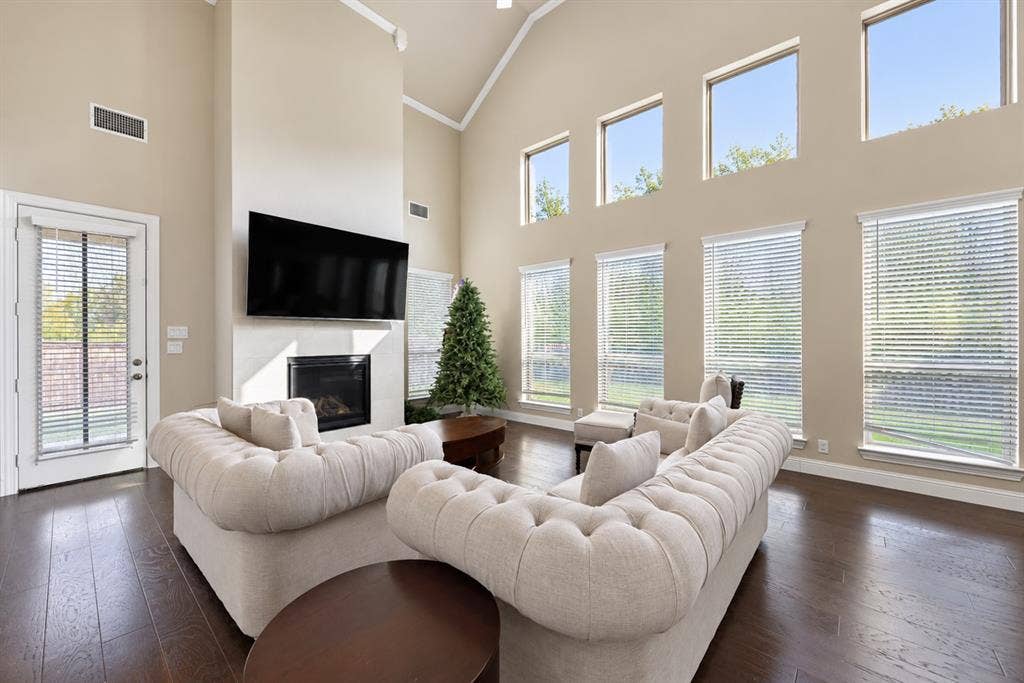 1603 Coventry Court, Farmers Branch, TX 75234 Vaulted ceilings, dark wood-finish flooring, a fireplace, and multiple windows with blinds