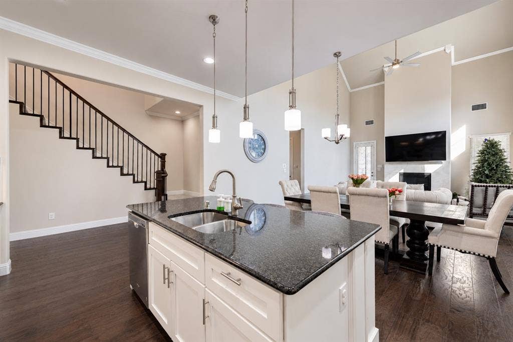 1603 Coventry Court, Farmers Branch, TX 75234 Kitchen island with dark countertop, stainless steel sink, and pendant lighting