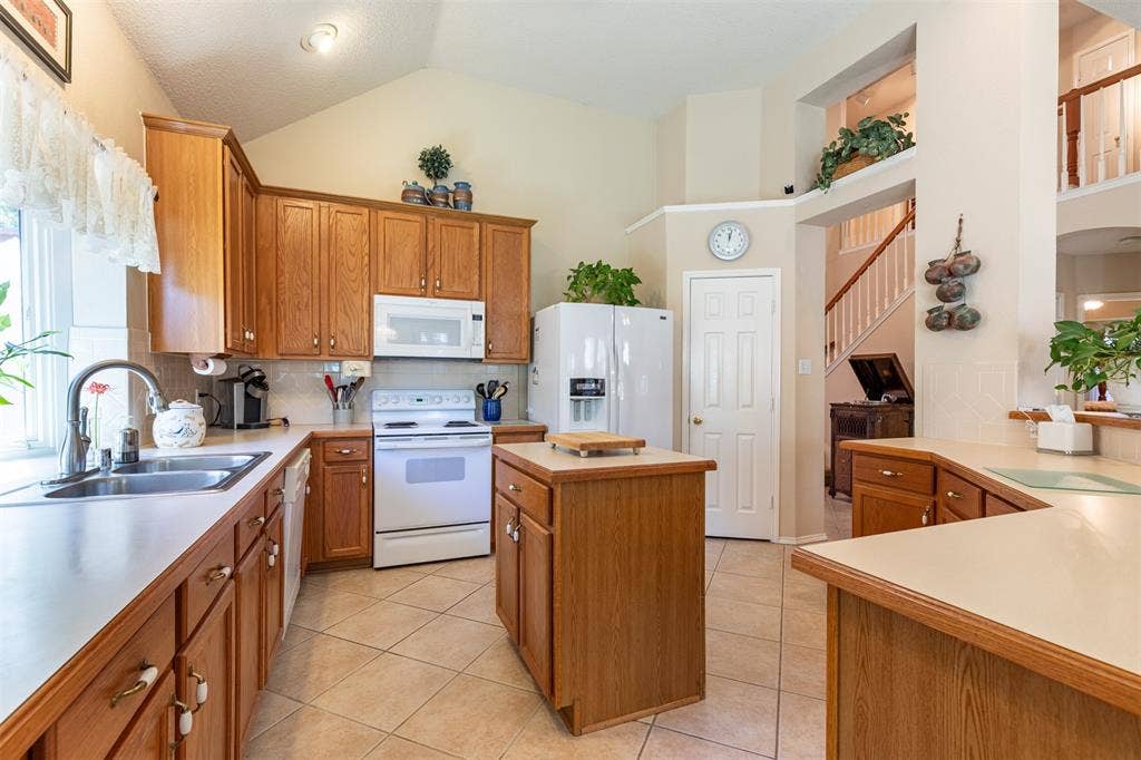 10208 Noel Drive, Frisco, TX 75035 Kitchen with wood cabinetry and prep island with storage.