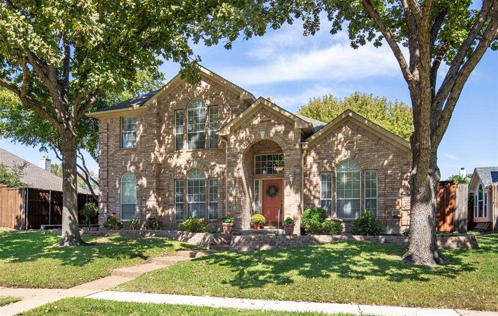 10208 Noel Drive, Frisco, TX 75035 Exterior features shad trees, bordered landscaping, and covered entry.
