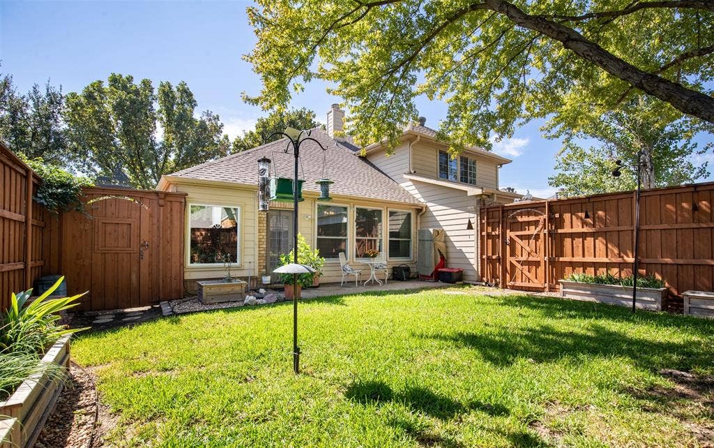10208 Noel Drive, Frisco, TX 75035 Beautiful backyard with landscaping and grassy yard.