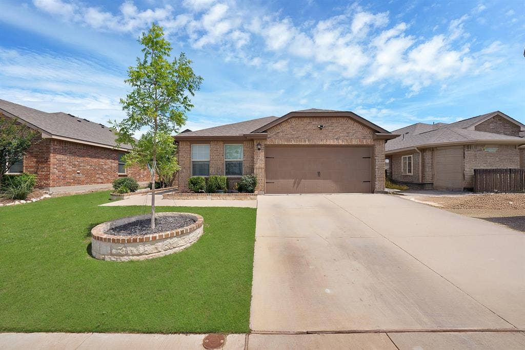 228 Foxhunter Street, Fort Worth, TX 76131 Brick exterior with an attached garage, concrete driveway, and front lawn