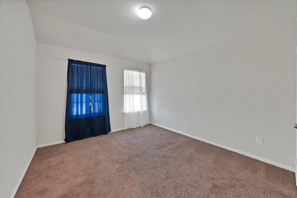 228 Foxhunter Street, Fort Worth, TX 76131 Carpeted interior with two windows and a ceiling-mounted light fixture