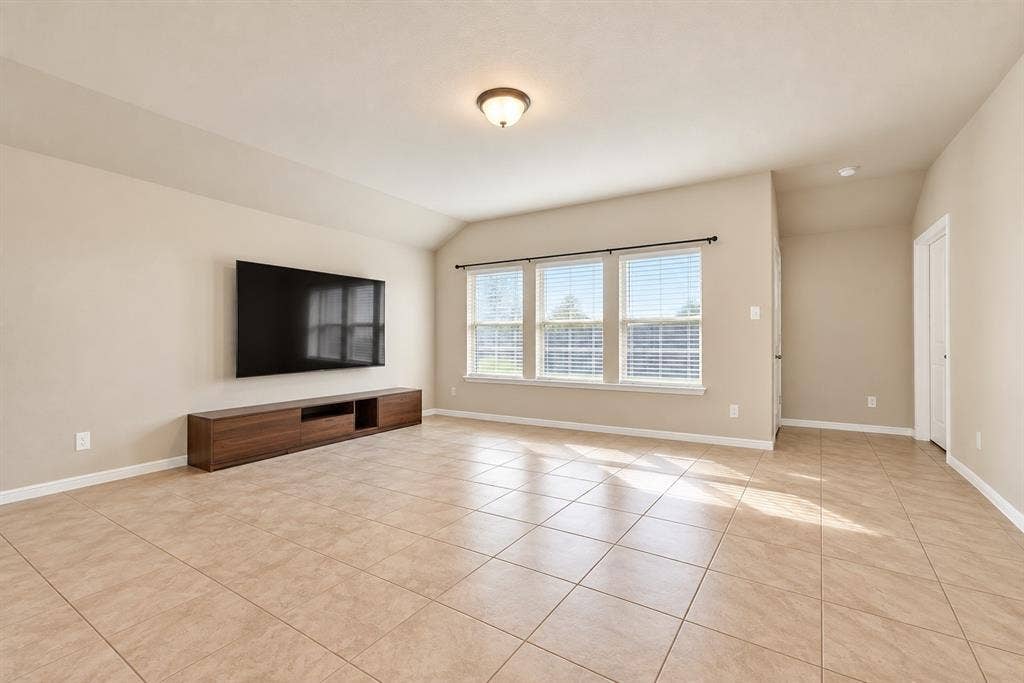 228 Foxhunter Street, Fort Worth, TX 76131 Vaulted ceiling, three large windows with blinds, recessed lighting, tile flooring, and a built-in media console