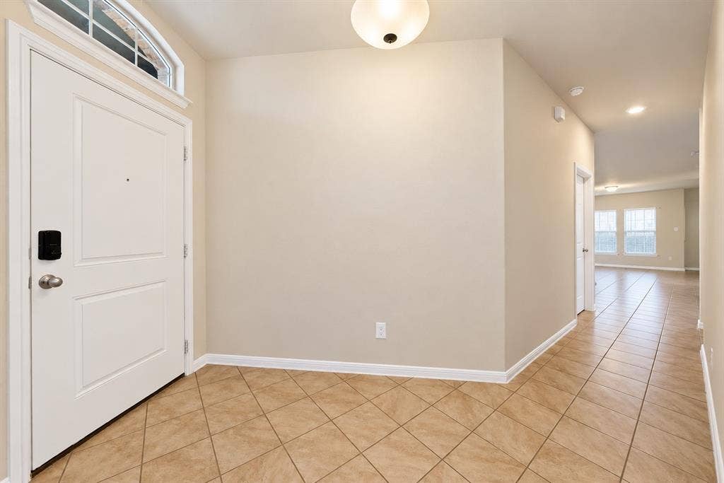 228 Foxhunter Street, Fort Worth, TX 76131 Entryway featuring a white paneled door with an arched transom window, a flush mount ceiling light fixture, and diagonal tile flooring