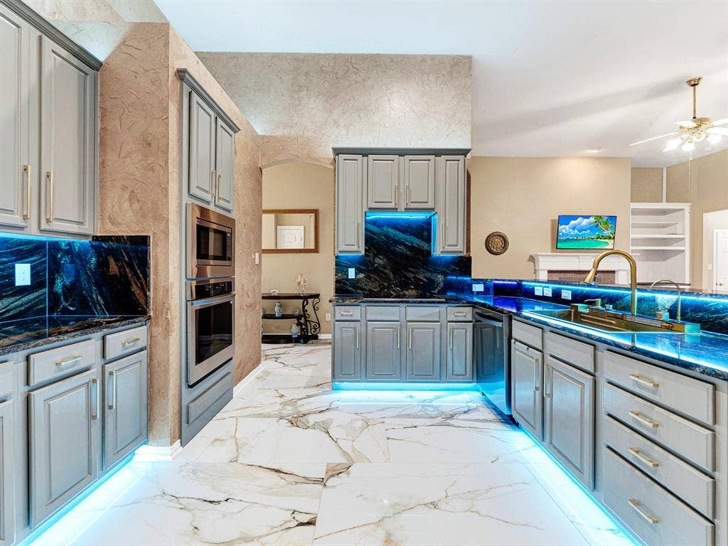 Customizable LED lighting beneath the cabinets and along their bases adds a personal touch to the kitchen. Choose a cheerful color for an afternoon of baking and tasting something sweet.