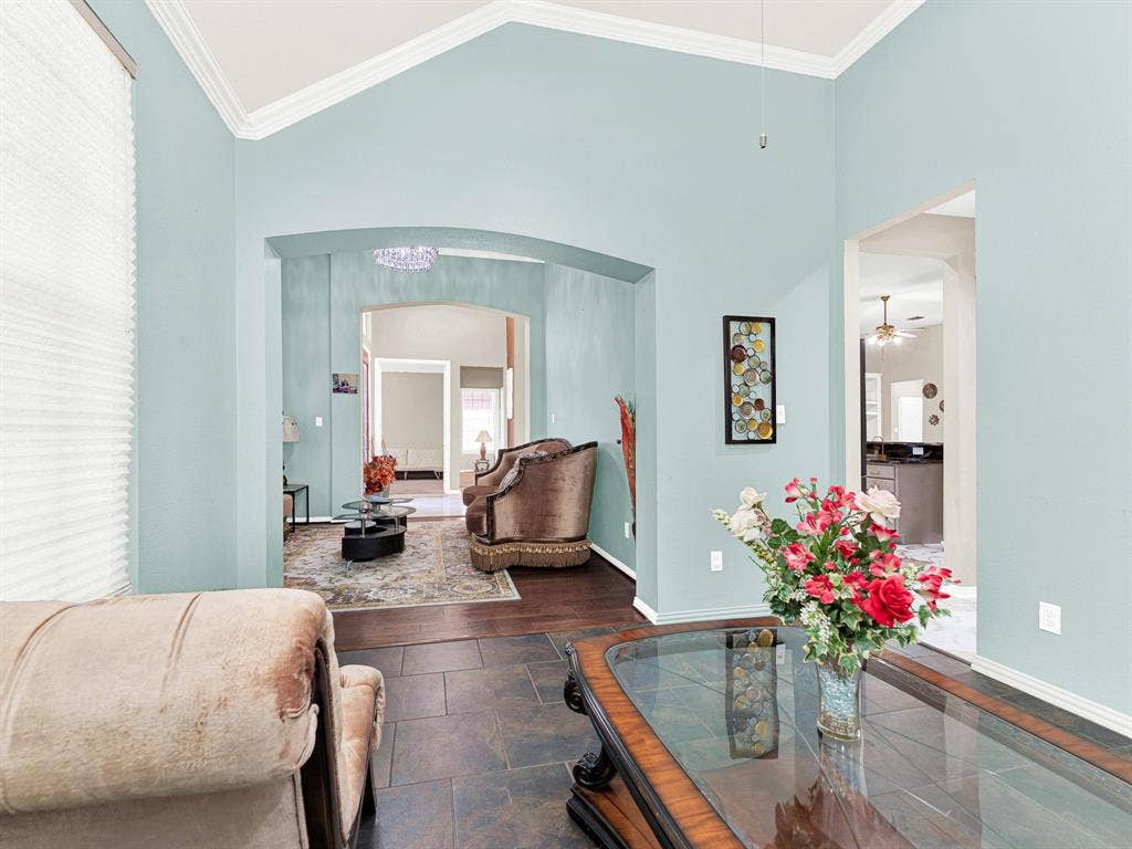 A broad arch connects this room to the front living area, while a separate kitchen doorway offers convenient access for entertaining. Host a relaxed dinner, then let guests drift into the adjoining room to continue their stories.